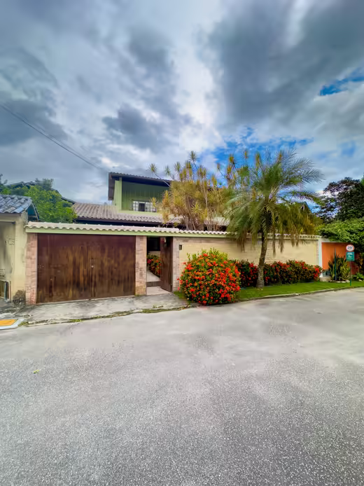 Fachada da casa com jardim e palmeira