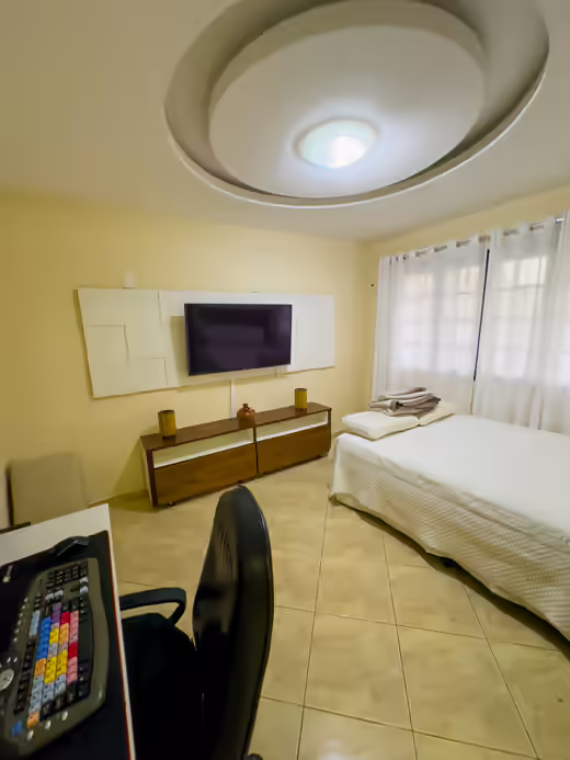 Suíte 2: quarto com cama e painel para televisão